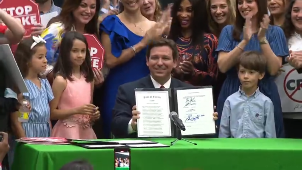 Ron DeSantis, le gouverneur de Floride, signe la loi HB7 surnommée loi «stop woke», ainsi que la loi sur le statut spécial de Disney World, lors d’une conférence de presse au collège et lycée privé Mater Academy, à Hialeah Gardens, en Floride, le 22 avril 2022.
